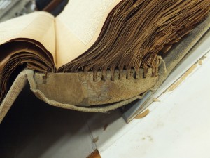 Side view of scrapbook showing unusual binding material.